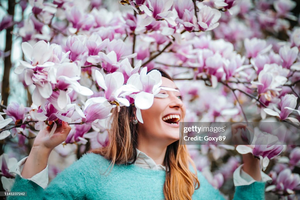 Amazing young woman posing in apricot tree orchard at spring