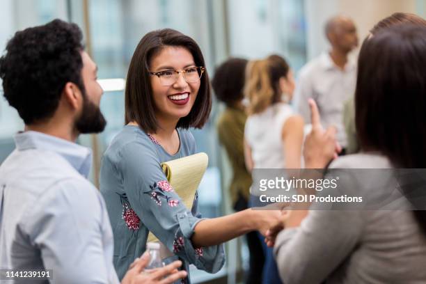 cheerful businesswoman shakes hands with colleague - asian seminar stock pictures, royalty-free photos & images