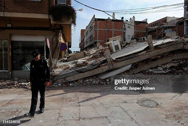 Policeman walks by a collapsed building, one day after a magnitude 5.1 quake killed at least 9 people, on May 12, 2011 in Lorca, Spain. After...