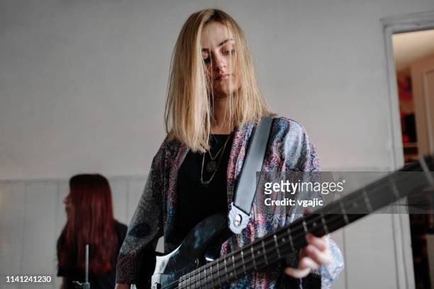 female bass guitarist on rehearsal - music rehearsal stock pictures, royalty-free photos & images