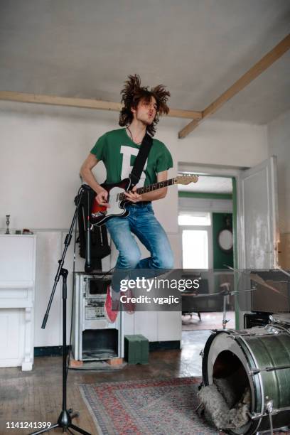 male guitarist on rehearsal playing guitar - rock group stock pictures, royalty-free photos & images