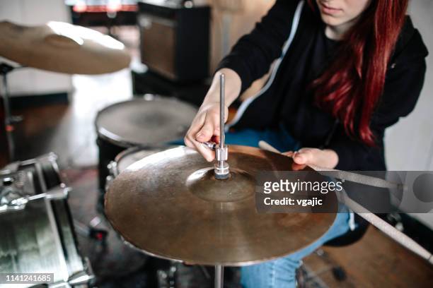 female drummer adjusting cymbal - cymbal stock pictures, royalty-free photos & images