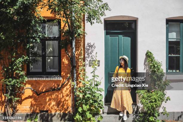 young woman standing in front of colorful buildings in copenhagen, denmark - northern europe foto e immagini stock