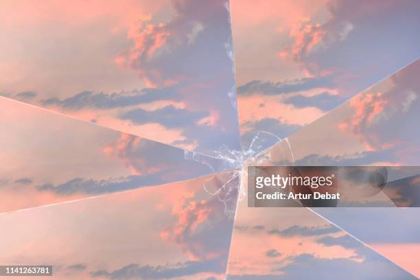 poetic picture of sunset sky with clouds seen through a broken mirror. - broken mirror stock pictures, royalty-free photos & images
