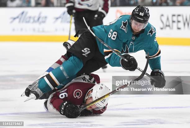 Melker Karlsson of the San Jose Sharks gets tripped up when Mikko Rantanen of the Colorado Avalanche falls to the ice in front of him during the...