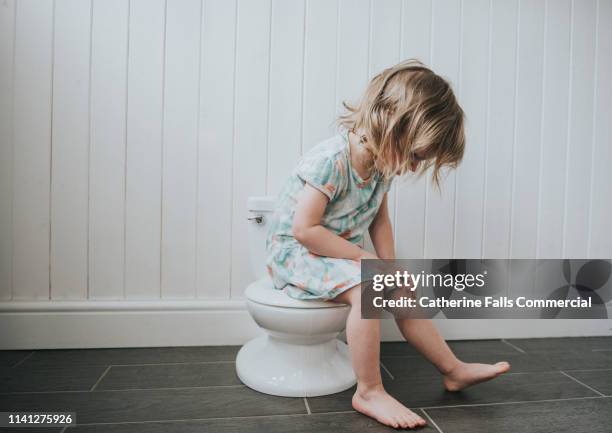 potty training - child urinating stockfoto's en -beelden