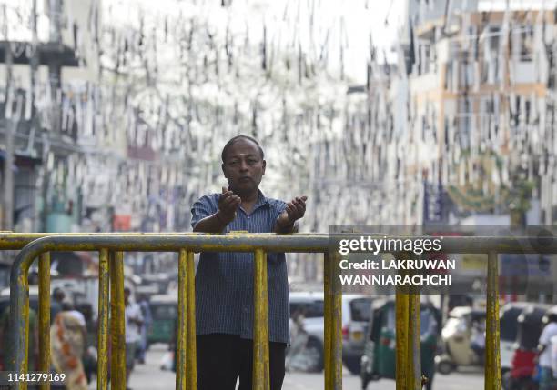 Sri Lankan Christian prays at a barricade near St. Anthony's Shrine in Colombo on May 5 two week after a series of bomb blasts targeting churches and...