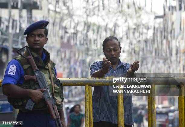 Sri Lankan Christian prays at a barricade near St. Anthony's Shrine in Colombo on May 5 two week after a series of bomb blasts targeting churches and...