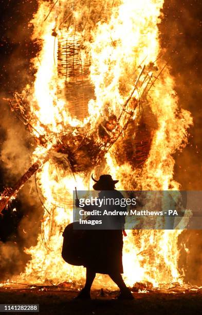 Member of the Pentacle Drummers is silhouetted in front of the burning wickerman during the Beltain Festival, an ancient Celtic celebration to mark...
