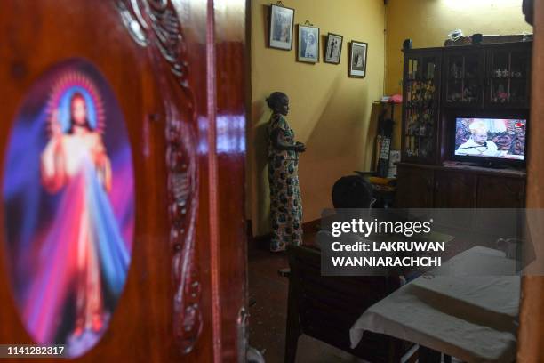 Sri Lankan Christians watch a live broadcast of a service conducted by the Archbishop of Colombo Cardinal Malcolm Ranjith, at their house near St....