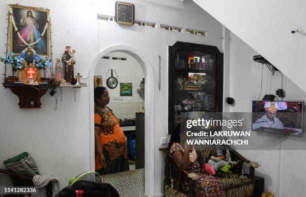 Sri Lankan Christians watch a live broadcast of a service conducted by the Archbishop of Colombo Cardinal Malcolm Ranjith, at their house near St....