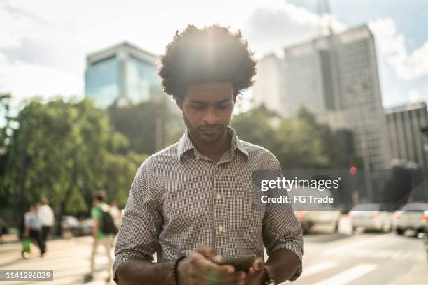 geschäftsmann mit handy auf der stadt - daily life in sao paulo stock-fotos und bilder