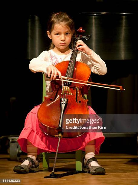 beginning cello student on stage. - one girl only stock pictures, royalty-free photos & images
