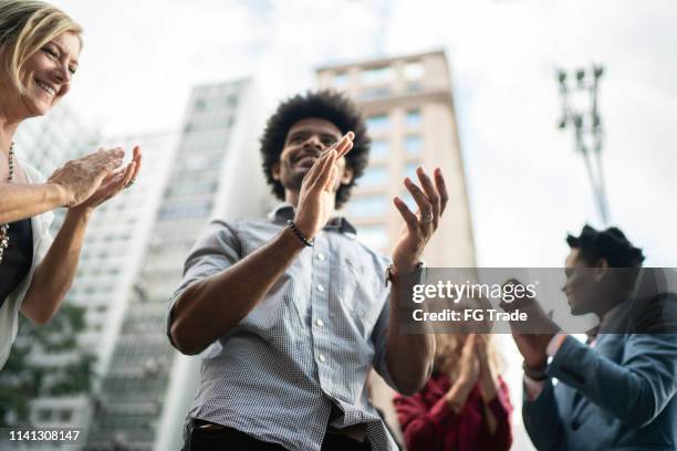 business team celebrating success applauding outdoors - applauding staff stock pictures, royalty-free photos & images