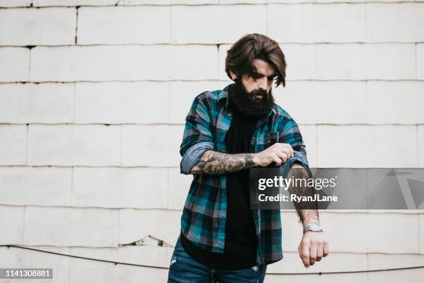 portrait of handsome bearded man by building wall - rolled up sleeves stock pictures, royalty-free photos & images