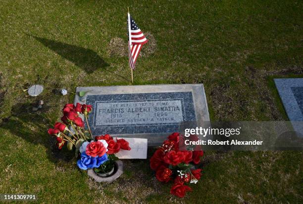 Flowers, an American flag and a note left by a fan surround the simple tombstone and grave of singer Frank Sinatra at Desert Memorial Park in...