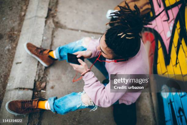 young man with dreadlocks enjoys music - music graffiti stock pictures, royalty-free photos & images