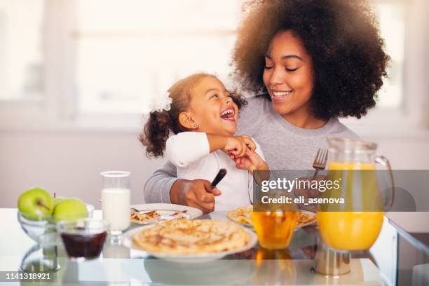 afroamerikanische junge mutter und tochter beim frühstück - black mother and child cooking stock-fotos und bilder