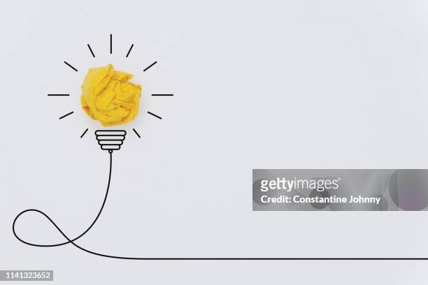 bulb concepts with yellow crumpled paper ball - innovation white background imagens e fotografias de stock