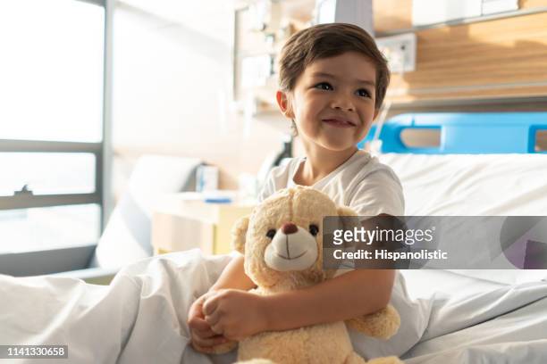 nahaufnahme des schönen kleinen jungen, der seinen teddybären umarmt, während er tagträume wegschaut - child in hospital stock-fotos und bilder