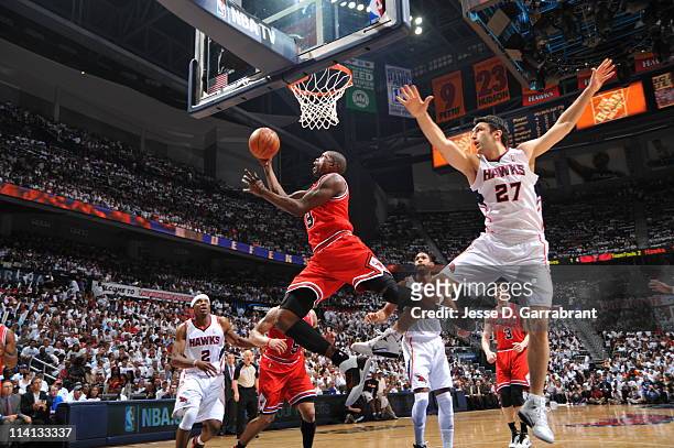 Luol Deng of the Chicago Bulls shoots against Zaza Pachulia of the Atlanta Hawks during Game Six of the Eastern Conference Semifinals in the 2011 NBA...