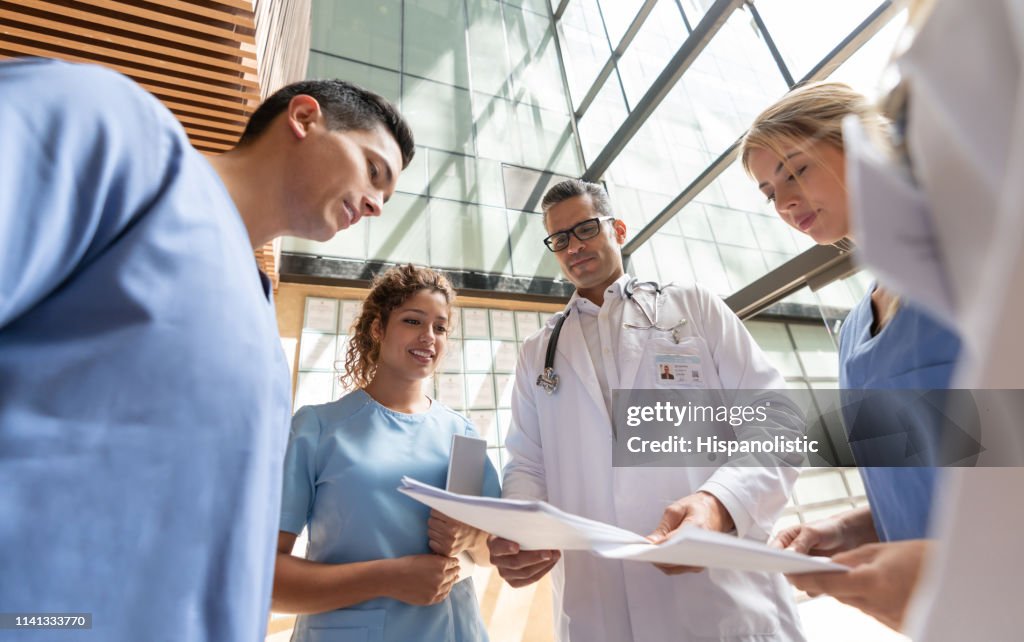 Hermosas enfermeras y doctores discutiendo algo mientras buscan papeleo
