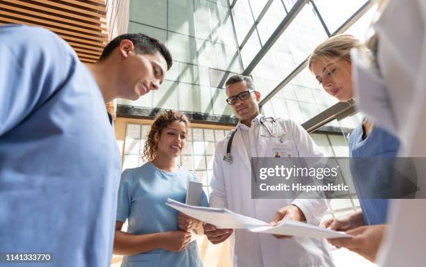 beautiful nurses and doctors discussing something while looking at paperwork - resident stock pictures, royalty-free photos & images