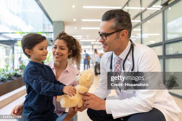 rapaz pequeno doce com sua mamã que mostra seu urso de peluche ao pediatra todo o sorriso muito feliz - mama bear - fotografias e filmes do acervo