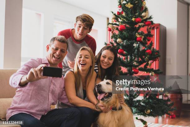 family celebrating christmas at home - christmas tree 50's stock pictures, royalty-free photos & images