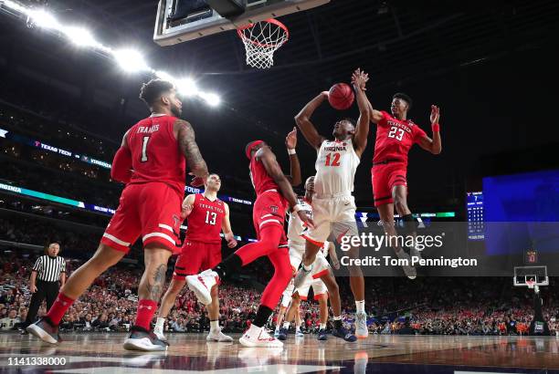 De'Andre Hunter of the Virginia Cavaliers attempts a shot against Tariq Owens and Jarrett Culver of the Texas Tech Red Raiders in the first half...