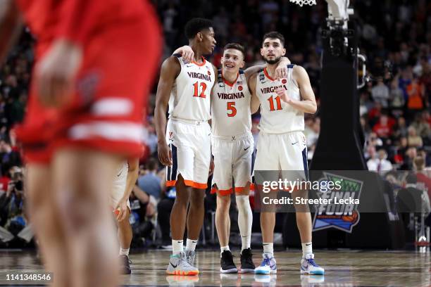 De'Andre Hunter, Kyle Guy and Ty Jerome of the Virginia Cavaliers celebrate their teams lead late in overtime against the Texas Tech Red Raiders...