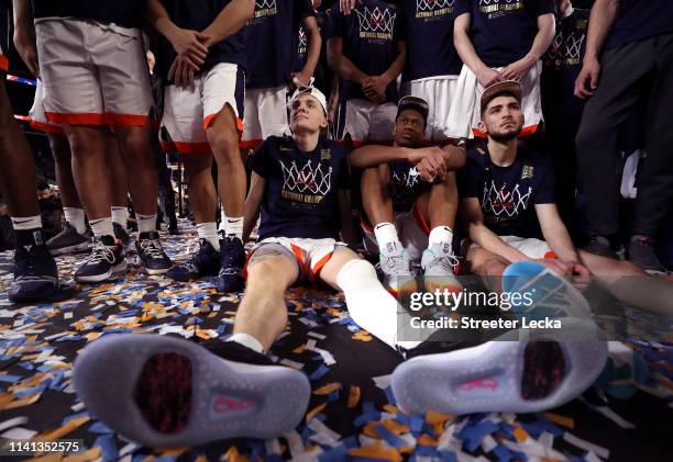Kyle Guy, De'Andre Hunter and Ty Jerome of the Virginia Cavaliers looks on during the teams celebrations after the 85-77 win over the Texas Tech Red...