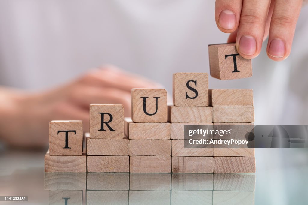 Mano de la mujer colocando el último alfabeto de Word Trust