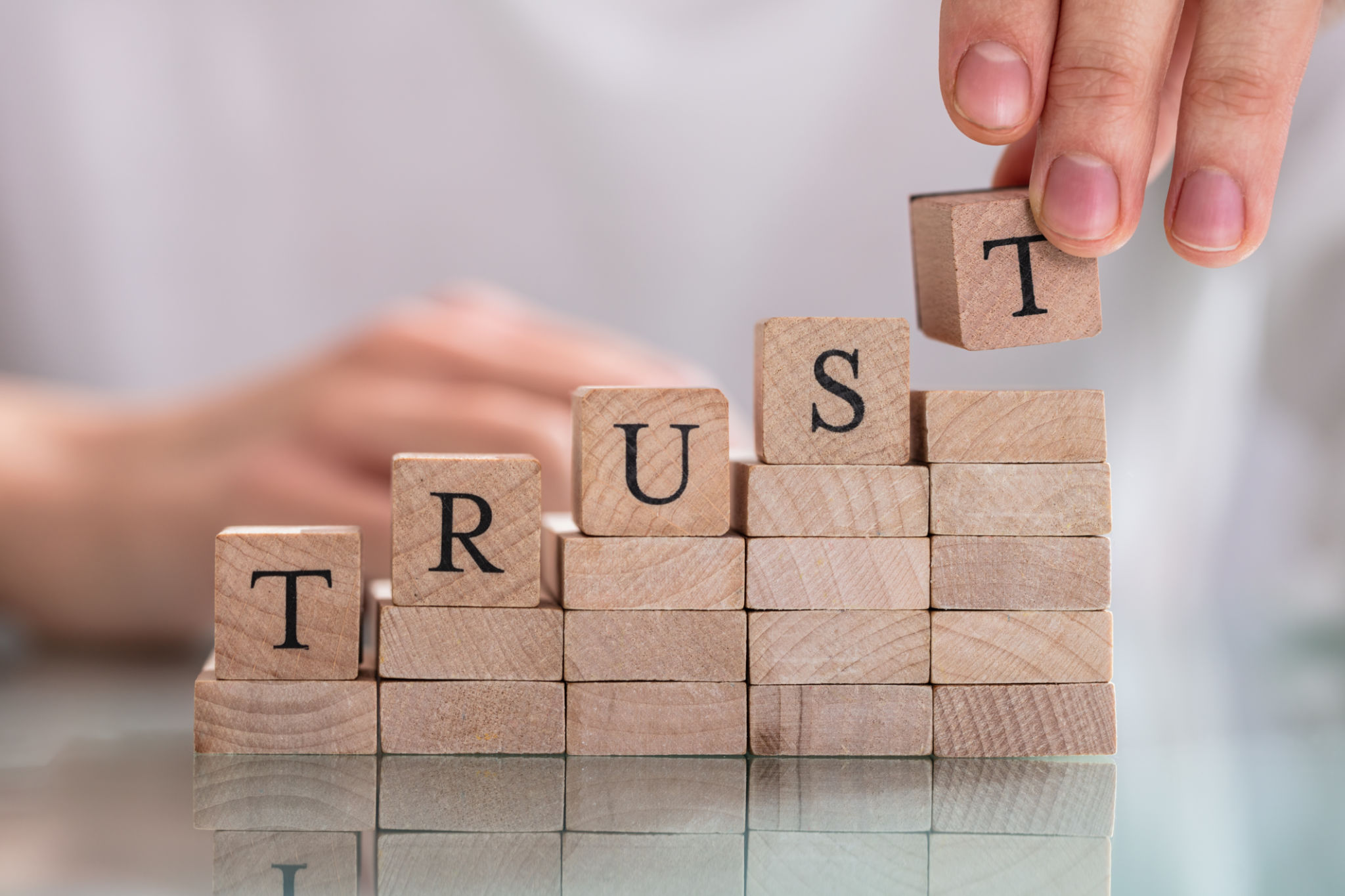 Woman's Hand Placing Last Alphabet Of Word Trust Woman's Hand Placing Last Alphabet Of Word Trust