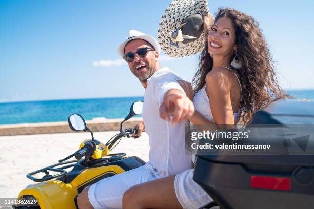 giovane coppia che si diverte a guidare scooter nel centro storico europeo - mare moto foto e immagini stock