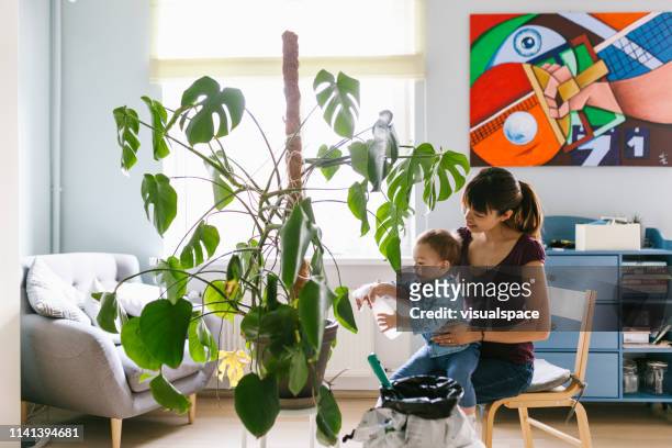 asiática madre e hijo cuidando la planta - bush baby fotografías e imágenes de stock