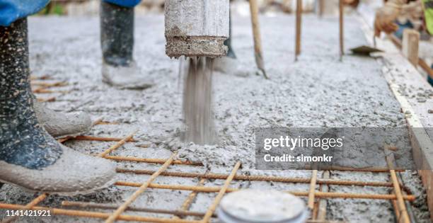 trabajadores de la construcción que vierten cemento en el tejado - hormigón fotografías e imágenes de stock