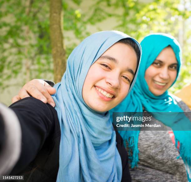 arab mother and daughter taking self portrait - arab mother and daughter taking selfie imagens e fotografias de stock