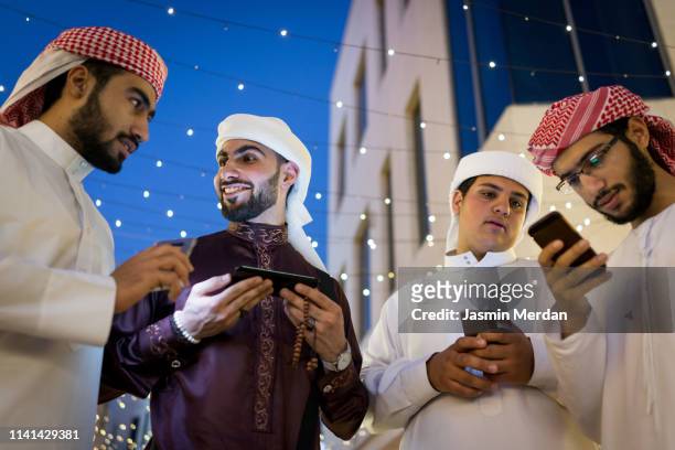 boys together out with smart phones in hands - muslim boy stockfoto's en -beelden