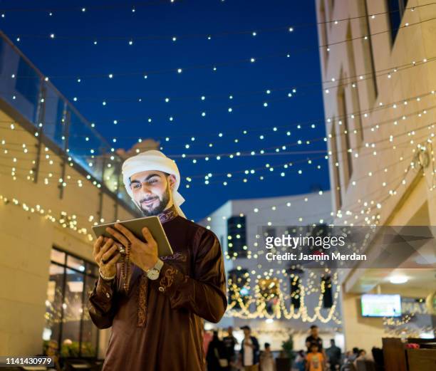 young man with tablet - united arab emirates night stock pictures, royalty-free photos & images