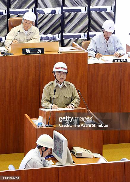 Iwanuma City Mayor Tsuneaki Iguchi makes a speech during the emergency meeting with wearing helmets as the ceiling of the chamber is in danger of...