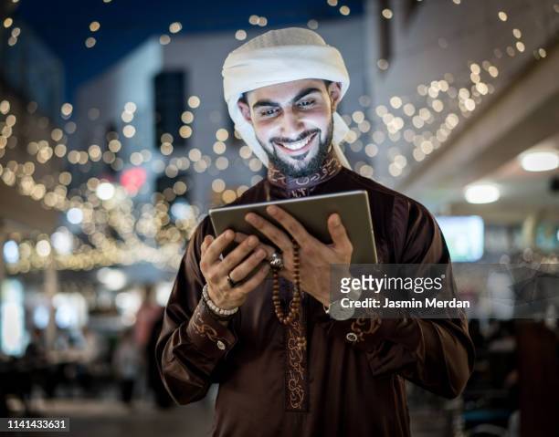 arab young man with tablet outdoors - bahrain city stock pictures, royalty-free photos & images