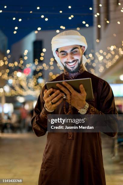 arab young man with tablet outdoors - bahrain people stock pictures, royalty-free photos & images