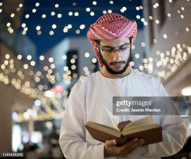 arab young adult reading book - middle eastern culture photos et images de collection