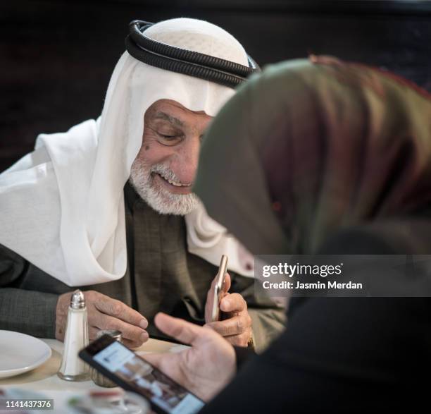 happy laughing mature arab man with kaffiyeh - old saudi man stock-fotos und bilder