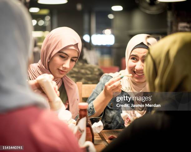 group of young arab girls having a talk - arabische frau kopftuch stock-fotos und bilder