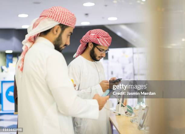 arab young men in electronic store shopping - arab shopping stockfoto's en -beelden