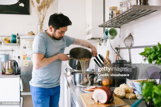 homme asiatique faisant le bouillon de soupe de ramen - bouillon photos et images de collection