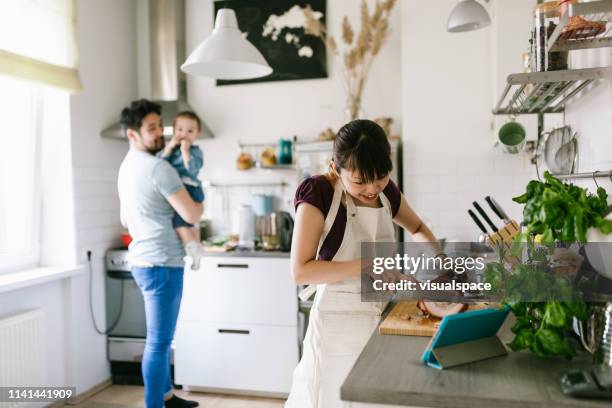 asian woman using the help of the digital cookbook - roast pig stock pictures, royalty-free photos & images