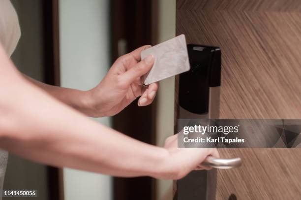 a young woman is opening a door using a card key - hotel suite stock pictures, royalty-free photos & images